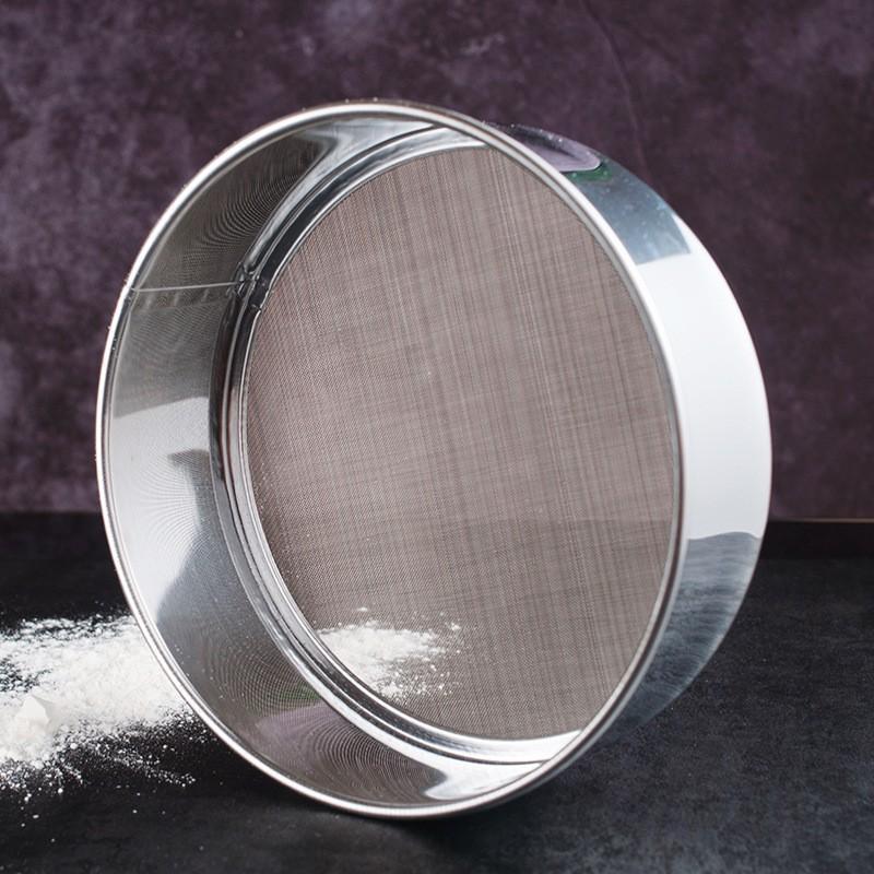 SteelSifter stainless steel flour sifter with ergonomic handle | Flour sifter with fine mesh screen for smooth baking | Stainless steel kitchen utensil sifting powdered sugar | SteelSifter sifting flour into mixing bowl | Durable stainless steel flour filter on wooden countertop | Ergonomic flour sifter used in baking preparation

