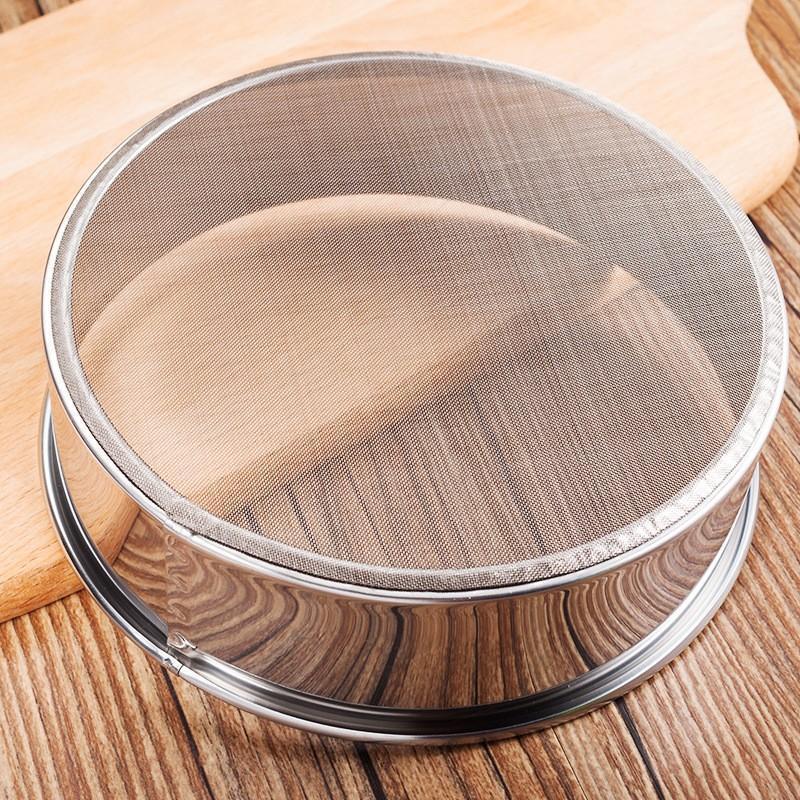 SteelSifter stainless steel flour sifter with ergonomic handle | Flour sifter with fine mesh screen for smooth baking | Stainless steel kitchen utensil sifting powdered sugar | SteelSifter sifting flour into mixing bowl | Durable stainless steel flour filter on wooden countertop | Ergonomic flour sifter used in baking preparation


