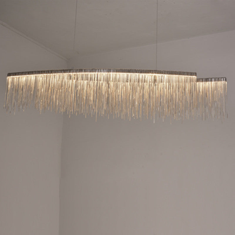 LumaGlow minimalist chandelier in dining room | Modern ceiling light fixture above dining table | Sleek chandelier with warm ambient lighting | Personalized chandelier installed in living room | Minimalist LED chandelier hanging in open space | Custom LumaGlow chandelier above modern dining setup | Elegant black and gold chandelier in minimal interior | Contemporary ceiling light with clean design | Scandinavian-style chandelier lighting a cozy room | Linear pendant chandelier for modern home décor